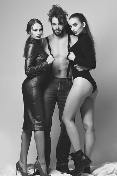 Relationship, seduction and fashion concept. Man and pretty girls - Photo, Image