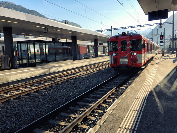 Tren suizo rojo en plataforma, Suiza
  - Foto, Imagen