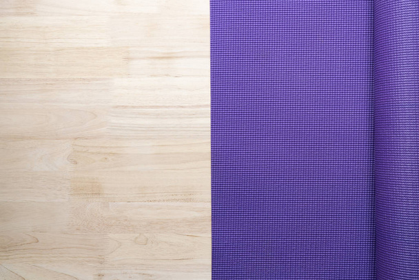 close up of purple yoga mat on the table, sport and healthy concept - Foto, afbeelding