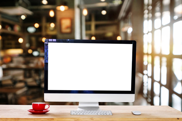 Monitor de computadora, teclado, taza de café y ratón con pantalla en blanco o blanco aislado está en la mesa de trabajo en el coffeeshop
  - Foto, Imagen