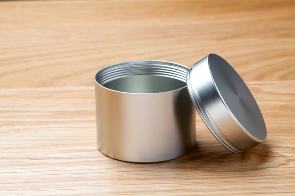Metal can for tea packaging on wooden table - 写真・画像
