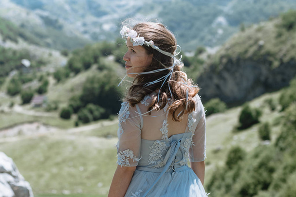 Bride in a dress walking along the road against the background of the mountains.  - Fotoğraf, Görsel