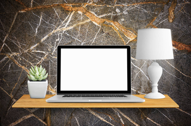 Laptop, lampade e cactus in vaso su libreria a parete, con schermo bianco
. - Foto, immagini