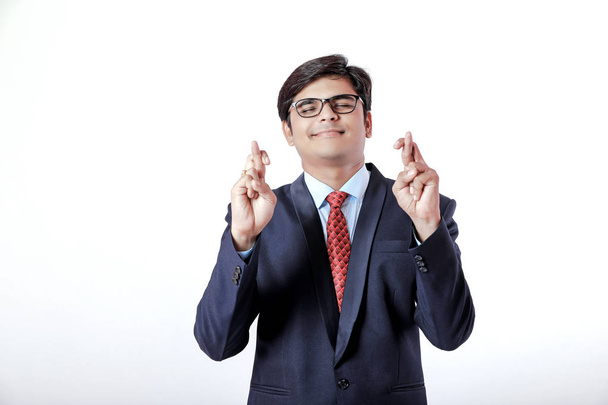 Joven hombre de negocios indio con su fondo de blanco cruzando los dedos - Foto, imagen