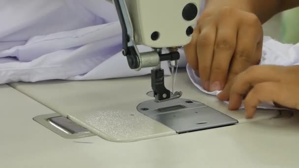 costurera en una máquina de coser hace una camisa en el taller de costura. la mujer en la máquina cose el cuello y los puños
 - Metraje, vídeo
