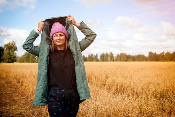 Foto's Outdoor mode voor jonge mooie vrouw in gouden veld in warme herfst winter. Gezellige herfst jas - Foto, afbeelding