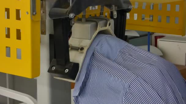 een vrouw in de winkel naaien op de pers machine geeft de vorm van de kraag van een overhemd - Video