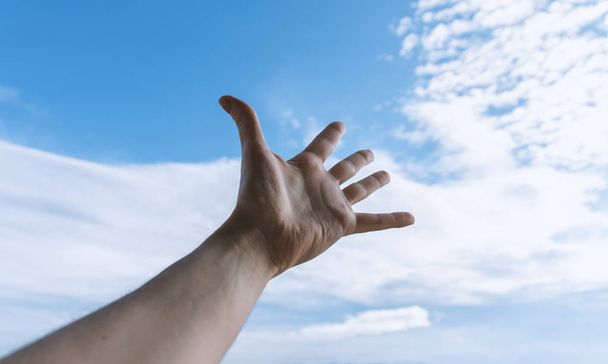 Hand of a man reaching to towards sky. - Valokuva, kuva