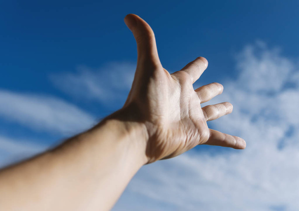 Hand of a man reaching to towards sky. - Zdjęcie, obraz