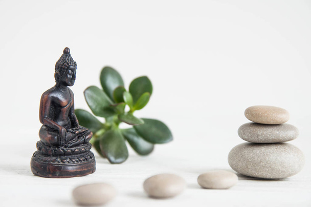 Пирамиды белых камней дзен с зелеными листьями и статуей Будды. Концепция гармонии, баланса и медитации, спа, массажа, отдыха
 - Фото, изображение