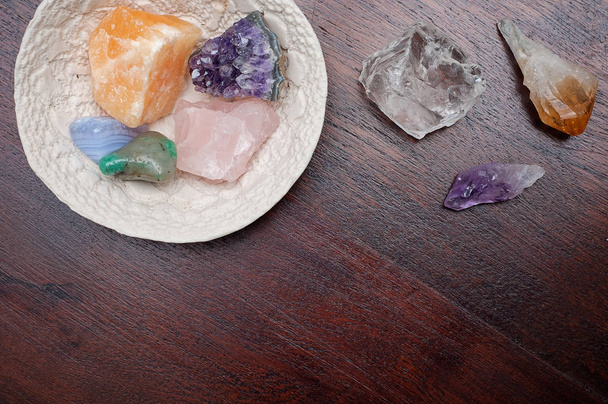 Heilkristalle auf einem Holztisch, darunter: Klarquarz, Citrin, Achat, Aventurin, Calcit, Amethyst und Rosenquarz. Edelsteine werden für ihre gute Stimmung zum Beispiel beim Meditieren verwendet. - Foto, Bild