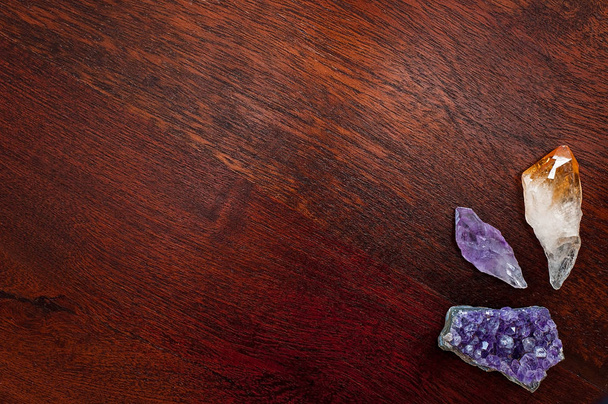 Léčení krystaly a kameny: ametysty a citrín bod na dřevěný stůl. Drahé kameny se používají pro jejich dobré vibrace aby vnitřní sílu, pozitivní energii a vnitřní klid - Fotografie, Obrázek