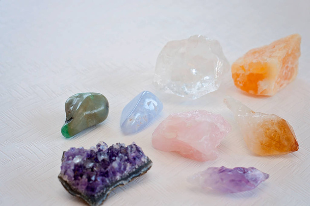 Des cristaux de guérison colorés apportent des vibrations positives : Agate de dentelle bleue, améthyste, quartz clair, citrine, calcite et quart de rose sur une table blanche
 - Photo, image