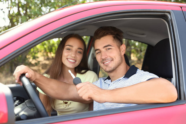 Happy young couple in new car on road trip - Photo, image