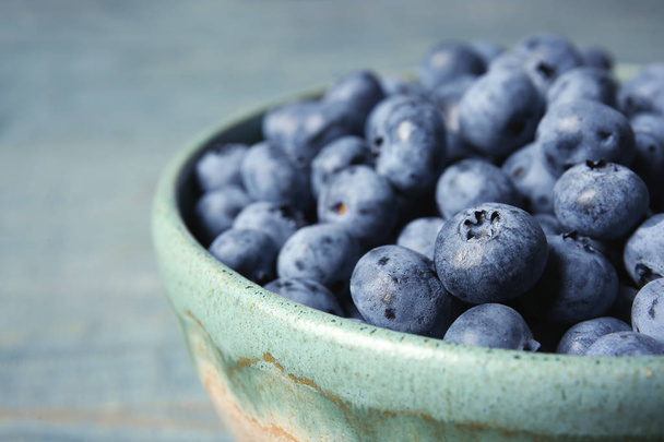 Crockery with juicy and fresh blueberries on wooden table, closeup - Foto, immagini