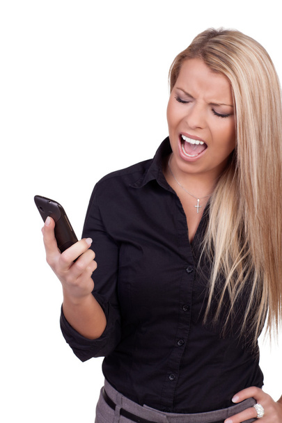 vrouw kijken naar haar mobiele in frustratie - Foto, afbeelding