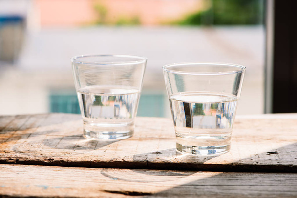 Δύο ποτήρια νερό στο τραπέζι σε ξύλινα φόντο - Φωτογραφία, εικόνα