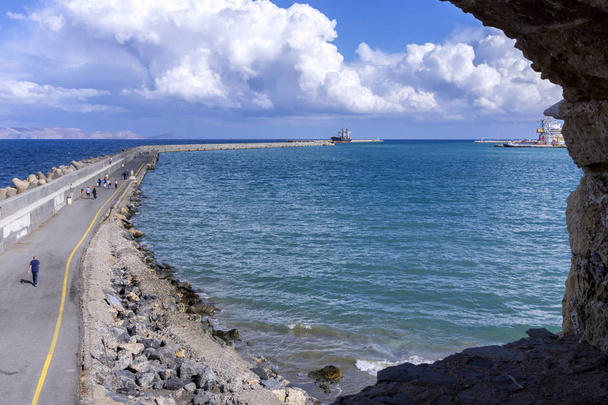 Veduta dalle mura della fortezza veneziana Koules (Castello a Mare) a Heraklion, Creta - Grecia. Gente che cammina sul molo del porto di Heraklion. Isola di Dia sullo sfondo
 - Foto, immagini