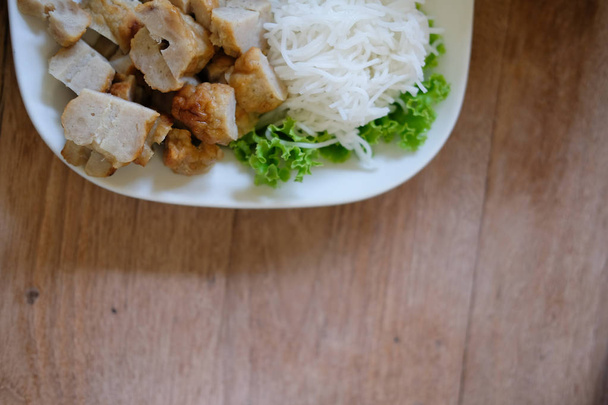 embutido de cerdo picado, fideos de arroz fermentado y verduras servidas con salsa de chile. comida vietnamita del rollo de verano llamada Nem Nuong Xa
 - Foto, Imagen