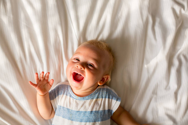 Beautiful baby boy, sweet child, lying in bed, playing in bed after bath, sleeping - Fotografie, Obrázek