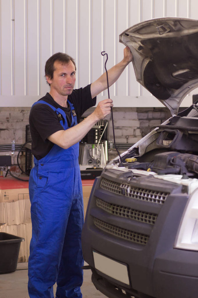 Technician working in the auto service and repairing a car - Foto, imagen