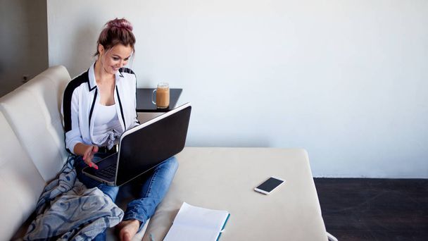 Kaunis tyttö työskentelee kotona kannettavan tietokoneen kanssa
 - Valokuva, kuva