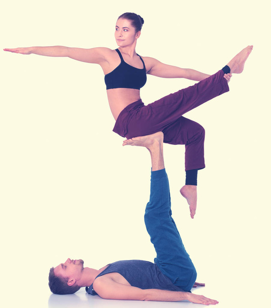 Young athletic couple practicing acroyoga. Balancing in pair - Zdjęcie, obraz