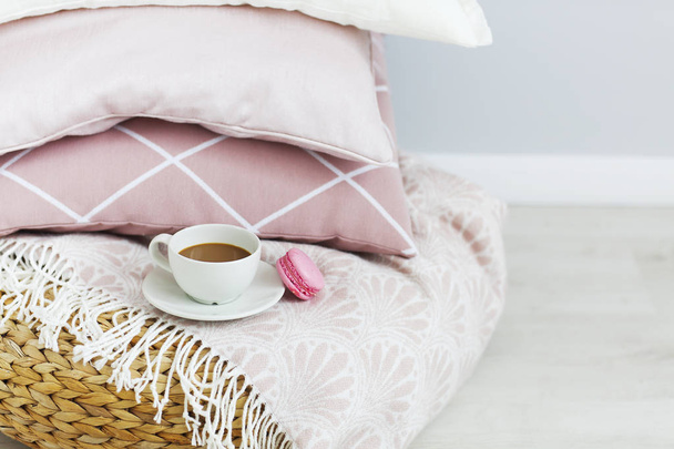Růžové a bílé polštáře a šálek kávy a macaron na zeď na pozadí. Detailní záběr - Fotografie, Obrázek