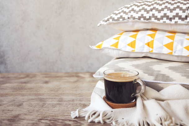 Almohadas amarillas y grises y taza de café en el fondo de la pared. De cerca.
 - Foto, imagen