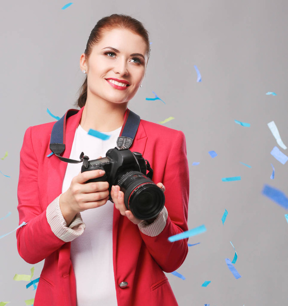 Beautiful happy woman with camera at celebration party with confetti . Birthday or New Year eve celebrating concept - Foto, afbeelding