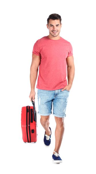 Young man walking with suitcase on white background - Fotografie, Obrázek