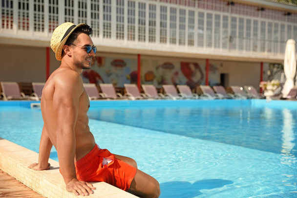 Young man near pool on sunny day - Foto, Imagen