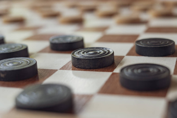 This is a wooden checkers board with black and white pawns game setup ready to play a - Fotografie, Obrázek