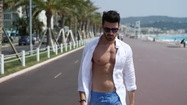 Attractive athletic young man on seaside promenade - Séquence, vidéo