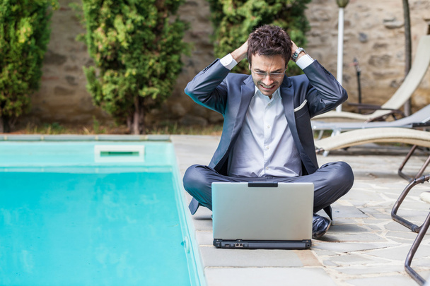 Young Businessman with Computer next to Swimming Pool - Zdjęcie, obraz