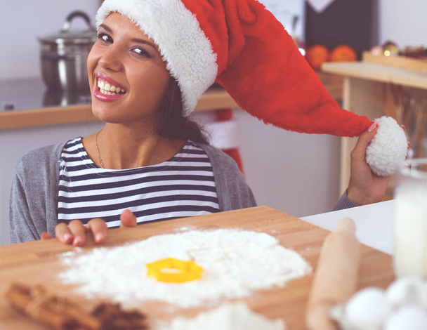 Mutlu genç bayan gülümsüyor Noel hazırlıklarıyla eğleniyor Noel Baba şapkası takıyor. - Fotoğraf, Görsel