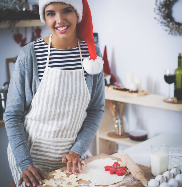 Woman making christmas cookies in the kitchen - Foto, immagini