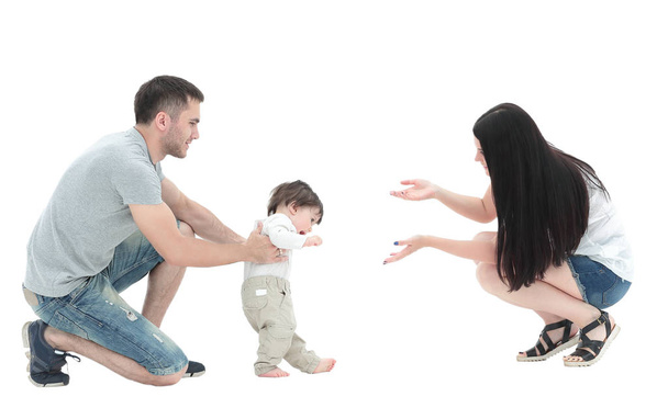 little boy making  first steps with the help of parents - Foto, imagen