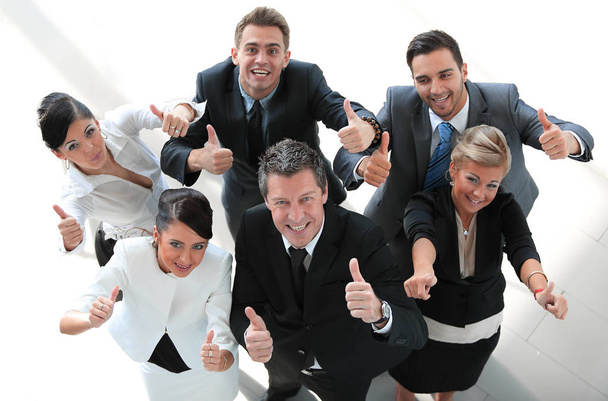 вид сверху. счастливая бизнес-команда, показывающая большой палец вверх
. - Фото, изображение