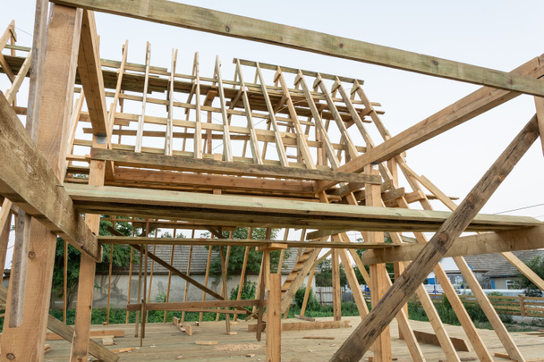 Balsas del marco de una casa de madera al atardecer. Construcción de una casa de marco en Ucrania
. - Foto, Imagen