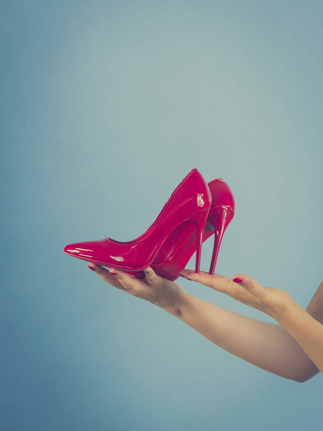 Woman hand fashion stylist presenting her elegant shoes. Beautiful red sensual high heels. Outfit accessories - Foto, afbeelding