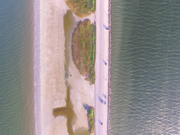 Ilmakuva kuuluisa Texas City Dike, pato, joka heijastaa lähes kahdeksan kilometriä kaakkoon suuhun Galveston Bay. Se suunniteltiin vähentämään sedimenttien kerääntymisen vaikutuksia alemmalla lahdella.
 - Valokuva, kuva