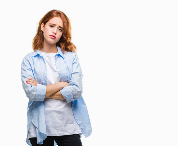Young beautiful business woman over isolated background skeptic and nervous, disapproving expression on face with crossed arms. Negative person. - Photo, Image
