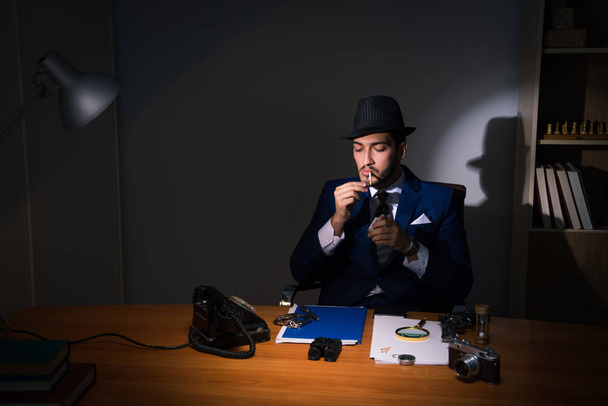 Detective sentado en habitación oscura en concepto vintage - Foto, imagen