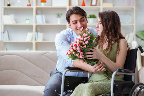 Hombre haciendo propuesta de matrimonio a mujer discapacitada en silla de ruedas - Foto, imagen