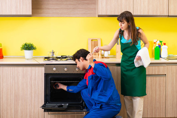 Femme avec entrepreneur à la cuisine discuter de réparation - Photo, image