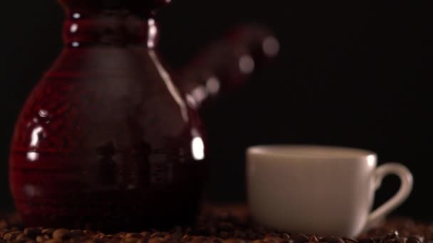 Low angle of a white cup and pot on coffee beans - Footage, Video