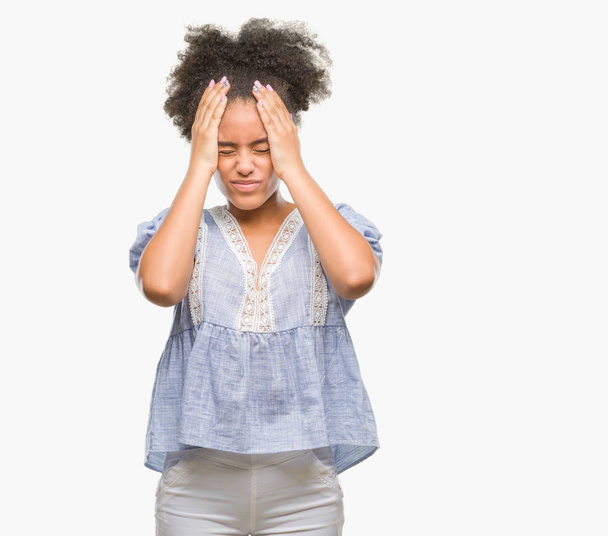 Jeune femme afro-américaine sur fond isolé souffrant de maux de tête désespérés et stressés parce que la douleur et la migraine. Mains sur la tête
. - Photo, image