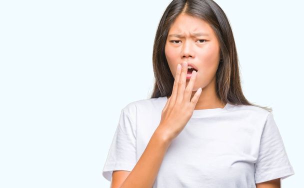 Young asian woman over isolated background bored yawning tired covering mouth with hand. Restless and sleepiness. - Photo, Image
