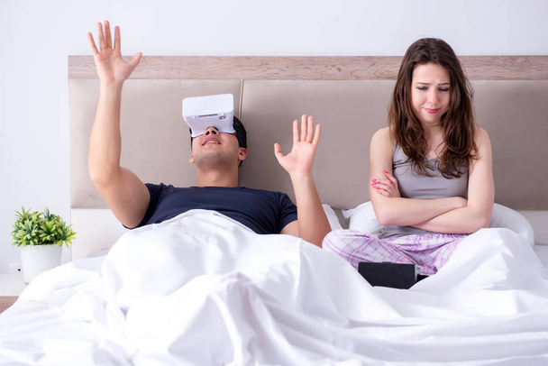 Vaimo ja aviomies virtuaalitodellisuus suojalasit sängyssä - Valokuva, kuva